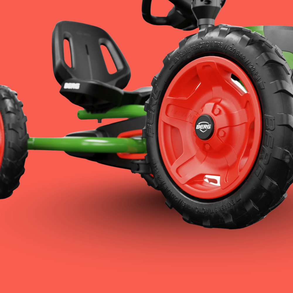 Children's pedal car with red wheels and black tires on a red background