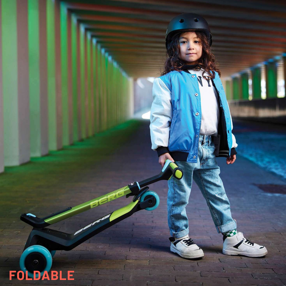 Child holding a foldable scooter in an urban setting