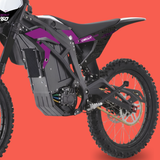 A close-up side view of an electric dirt bike or moped showing the black frame, battery housing, rear wheel, and purple and white graphics on the bodywork, set against a solid orange-red background.