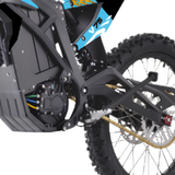 Close-up of a black off-road motorcycle or dirt bike frame, rear wheel, chain drive, and part of the blue and yellow V75 body panel on a white background.