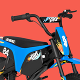 A close-up of a blue and black electric dirt bike with flame decals, number 84, and 'Go Skirtz' branding, set against a solid red-orange background.