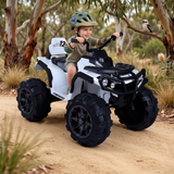 Child riding Go Skitz Adventure Electric Kids Quad Bike in a natural setting with trees and a bird.