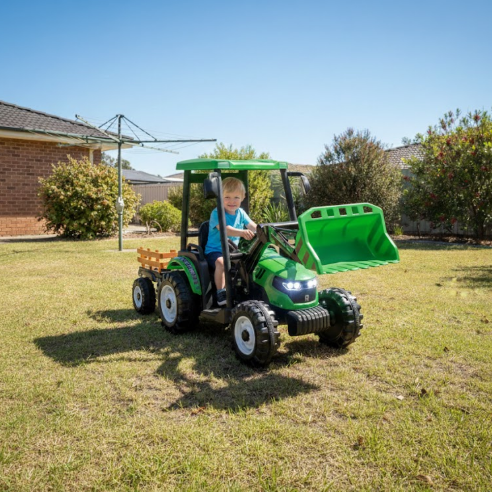 Child playing with a green toy tractor on grass