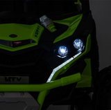 Close-up of a green and black off-road vehicle with illuminated headlights.