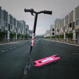 Lifestyle Image in Urban Setting: The scooter is shown outdoors on an empty street surrounded by modern buildings, emphasizing its suitability for urban environments.