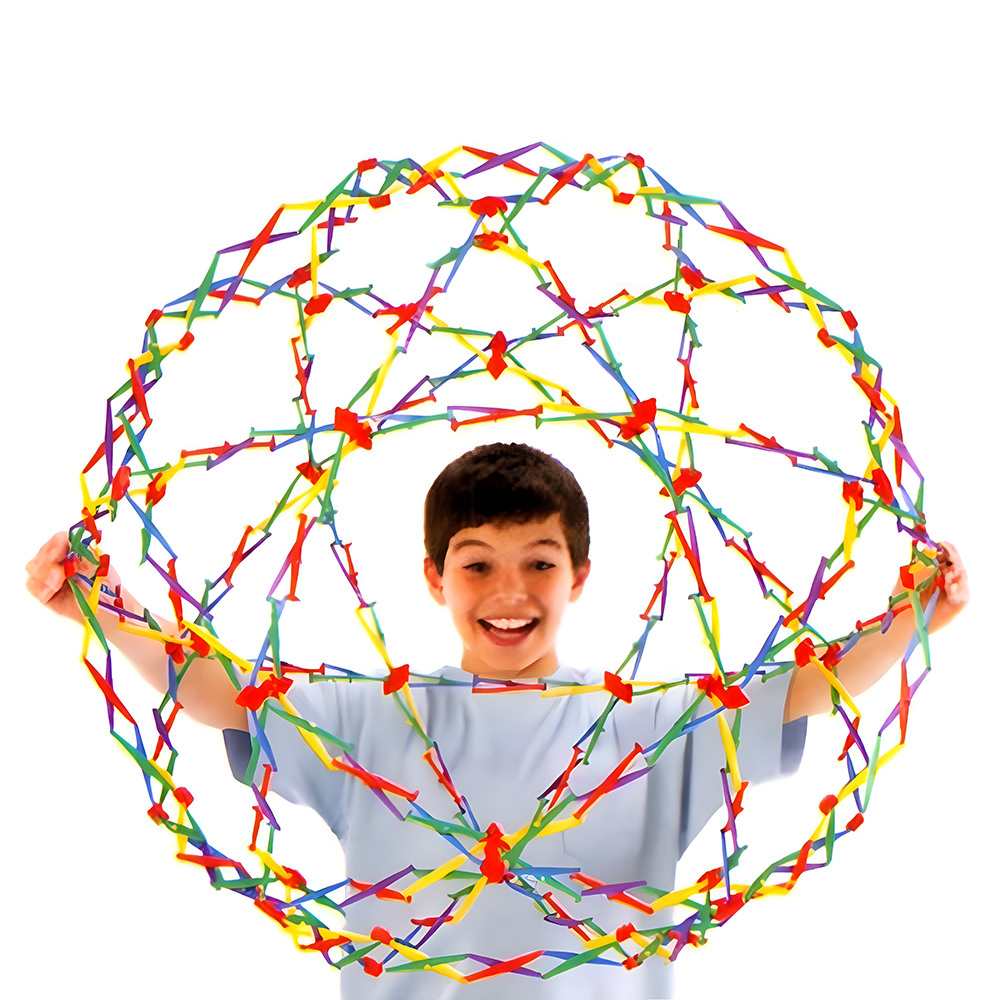 Young boy holding a large, multi-coloured Hoberman Sphere in its expanded form, smiling against a white background