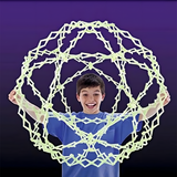 Young boy holding an expanded Hoberman Sphere that glows against a dark purple background, appearing mesmerised by the glowing effect.