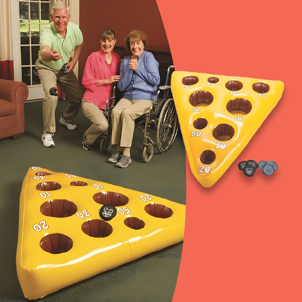 Elderly people playing the Mouse and Cheese Toss game, aiming to throw the mouse beanbag into holes on a yellow inflatable cheese mat