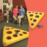 Elderly people playing the Mouse and Cheese Toss game, aiming to throw the mouse beanbag into holes on a yellow inflatable cheese mat