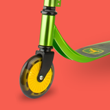 Close-up of a green scooter with a yellow wheel on a red background