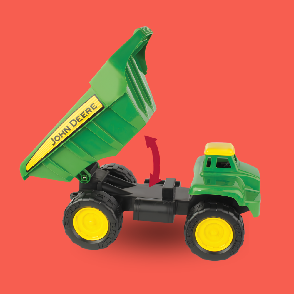 A green and yellow John Deere toy dump truck with its bed raised, shown on a solid red background. A red arrow graphic points upward near the bed to indicate lifting.