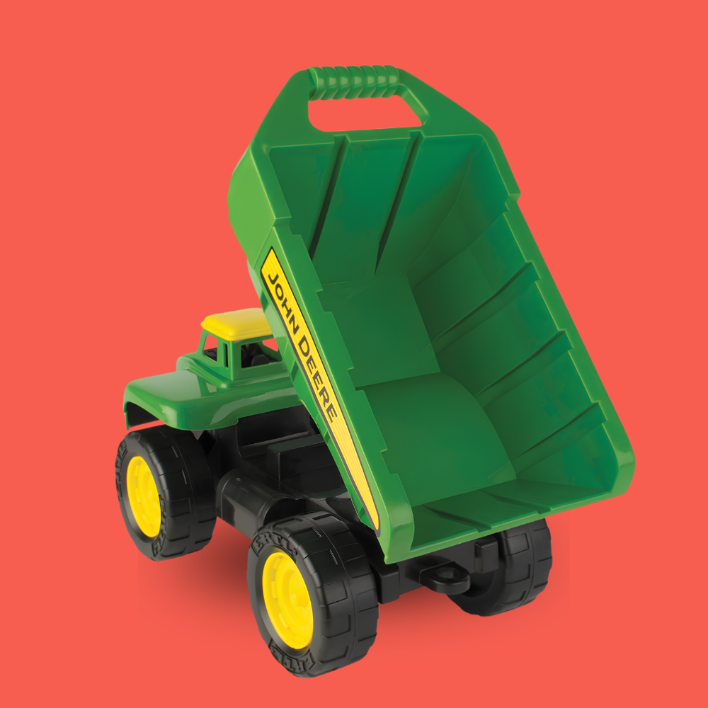A green and yellow John Deere toy dump truck with black wheels, shown on a solid coral-red background.