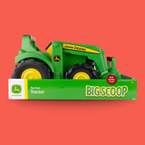 John Deere Big Scoop toy tractor in its original green and white packaging, displayed against a solid red background.