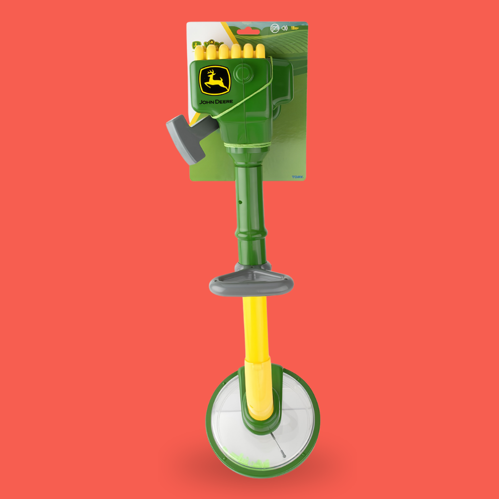 A John Deere push-to-charge cordless lawn mower battery pack in its retail packaging, displayed against a solid coral red background.