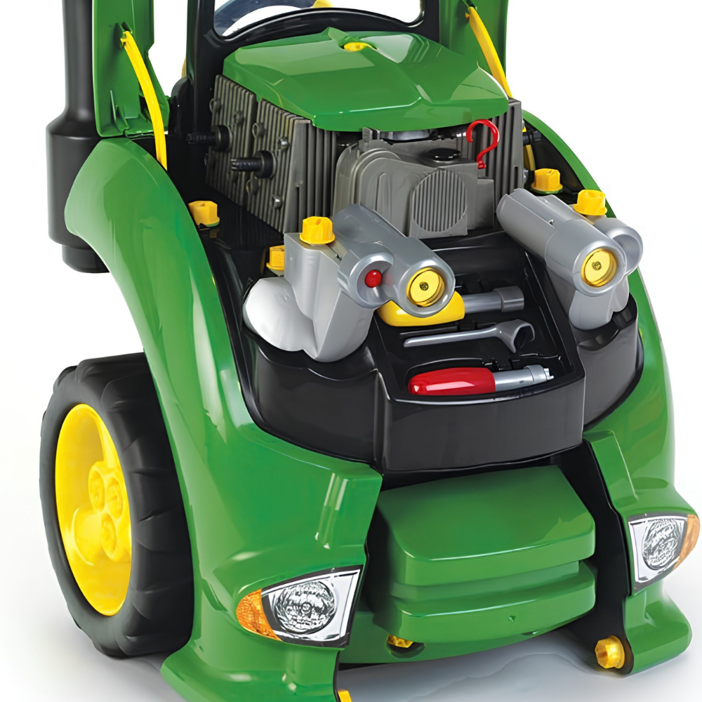 A green toy tractor with an open hood revealing a detailed toy engine bay, including silver toy headlights, yellow caps, and a red-handled tool, shown on a white background.