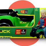 The John Deere Buck ATV ride-on toy in its retail packaging, featuring a green and yellow box with "TRY ME! 7 Realistic Sounds" text and an image of a smiling child in red overalls riding the toy.