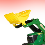 Green toy bulldozer with yellow scoop on a gradient background