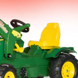 Green and yellow toy tractor with a yellow seat on a white background