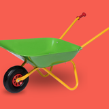 Colorful toy wheelbarrow on a red background