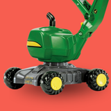 Toy excavator with green body and black and yellow wheels on a red background