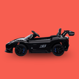 A black toy sports car with blue brake accents and a large rear spoiler, shown in profile against a solid coral-red background.