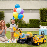 A young boy wearing a party hat stands on grass holding a bunch of colorful balloons while a woman claps nearby. In front of them are two yellow construction-themed ride-on toys, one excavator and one backhoe, set in an outdoor backyard scene.