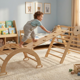Child playing on a wooden climbing toy in a room with books and toys.