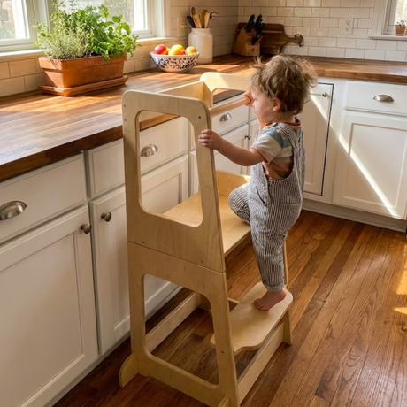 Child using a wooden step stool in a kitchen