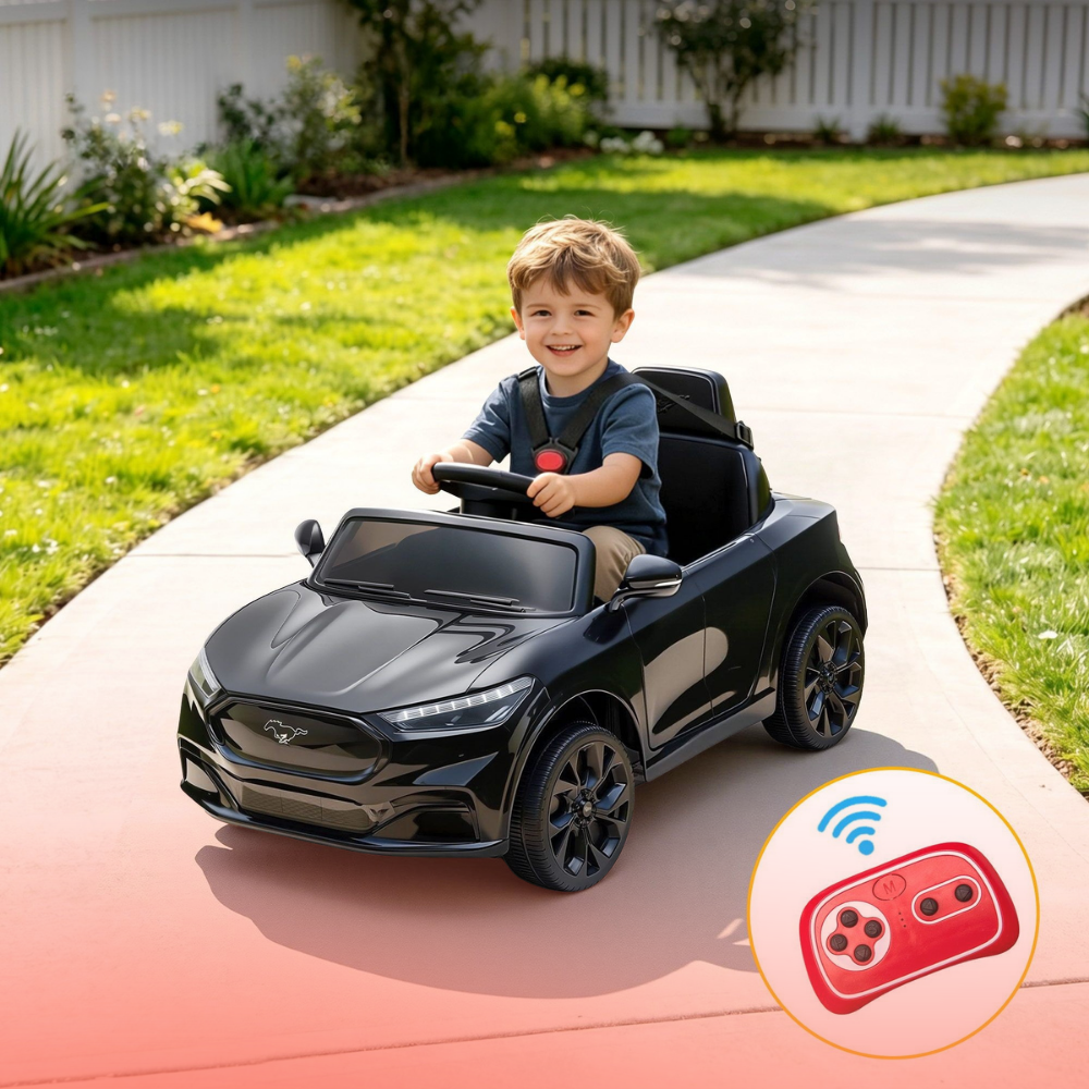 A young boy drives a black Ford-style toy car outdoors on a paved path, with grass, trees, and a white fence in the background. A circular inset in the lower right shows a red remote control with a wireless icon.