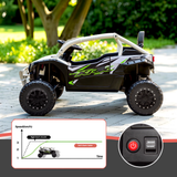 A black and white toy UTV quad bike with green graphics, shown outdoors on a paved path with trees in the background. The image includes a feature callout graphic showing speed settings and a close-up inset of a red power button and switch.