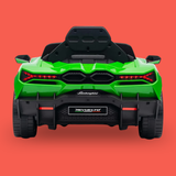 A green and black Lamborghini-style children's ride-on car shown from the rear on a solid coral-red background. The back features a glossy green body, black roll bar, red taillights, and a black rear bumper with a 'Revuelto' badge and 'Lamborghini' script.