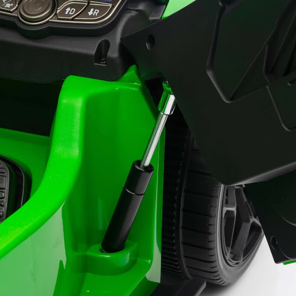 Close-up detail of a bright green and black ride-on toy vehicle, showing the side panel, wheel, and a black support rod.