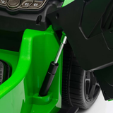 Close-up detail of a bright green and black ride-on toy vehicle, showing the side panel, wheel, and a black support rod.