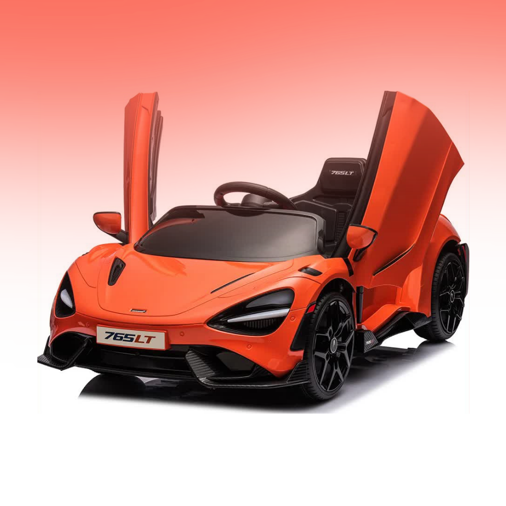 An orange children's ride-on toy car styled like a McLaren 765LT, featuring butterfly-style open doors, black wheels, and a black interior, shown on a white background with a pink gradient sky.