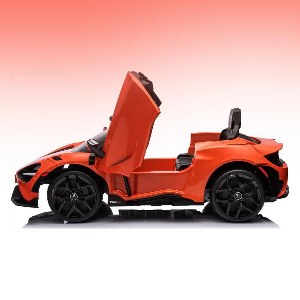 An orange and black kids' ride-on toy sports car with its door open, shown in a side profile against a pink-to-white gradient background.