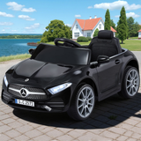Black toy car resembling a Mercedes-Benz, parked on a driveway with a scenic background.