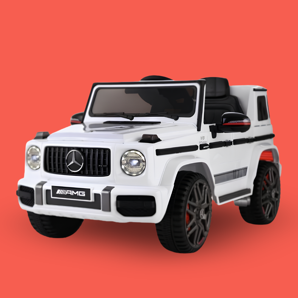 A white Mercedes-Benz AMG G-Class children's ride-on toy car with black wheels and interior, shown against a solid coral-red background.