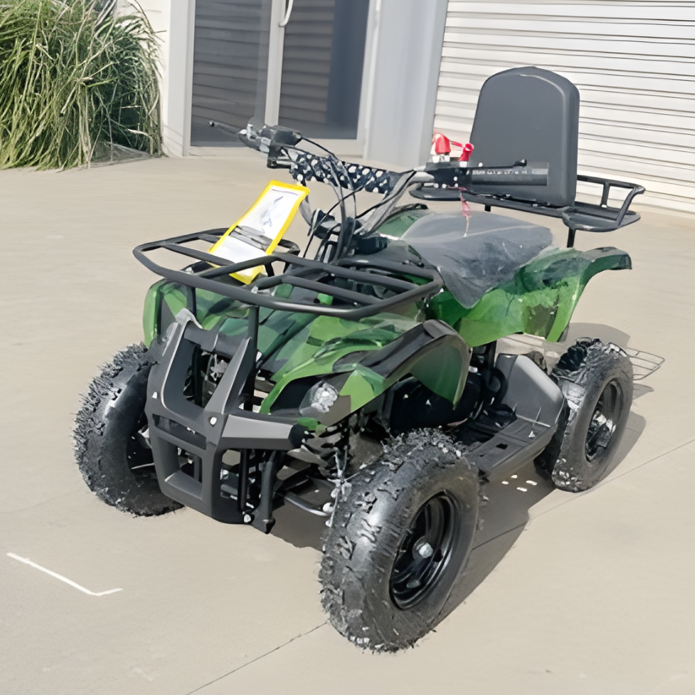 Green and black ATV parked on a concrete surface with a building in the background.