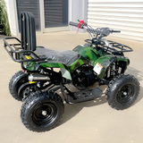 Green ATV parked on a concrete surface with a building in the background