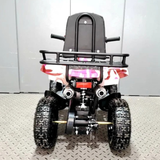 Children's ATV with a seat and front rack on a gray floor.
