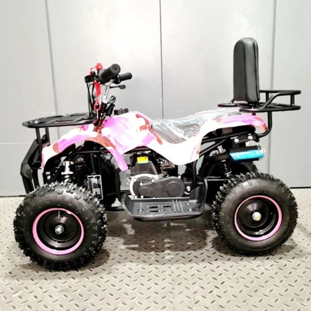 Small ATV with pink accents on a gray floor against a white wall