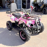 Pink and gray ATV parked on a concrete surface with a building in the background