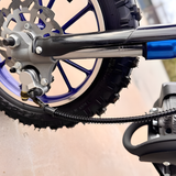 Close-up of a motorcycle wheel and suspension system with a blurred background