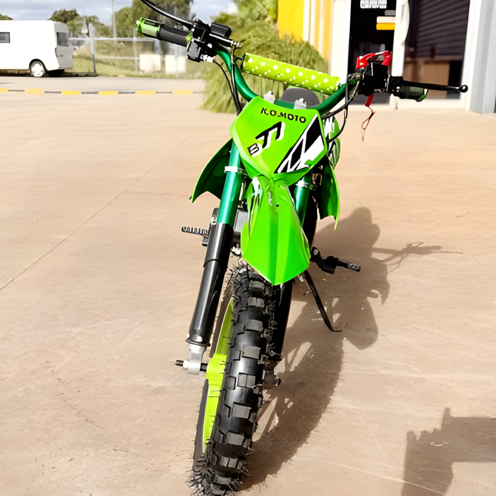 Green dirt bike with visible branding on a concrete surface.