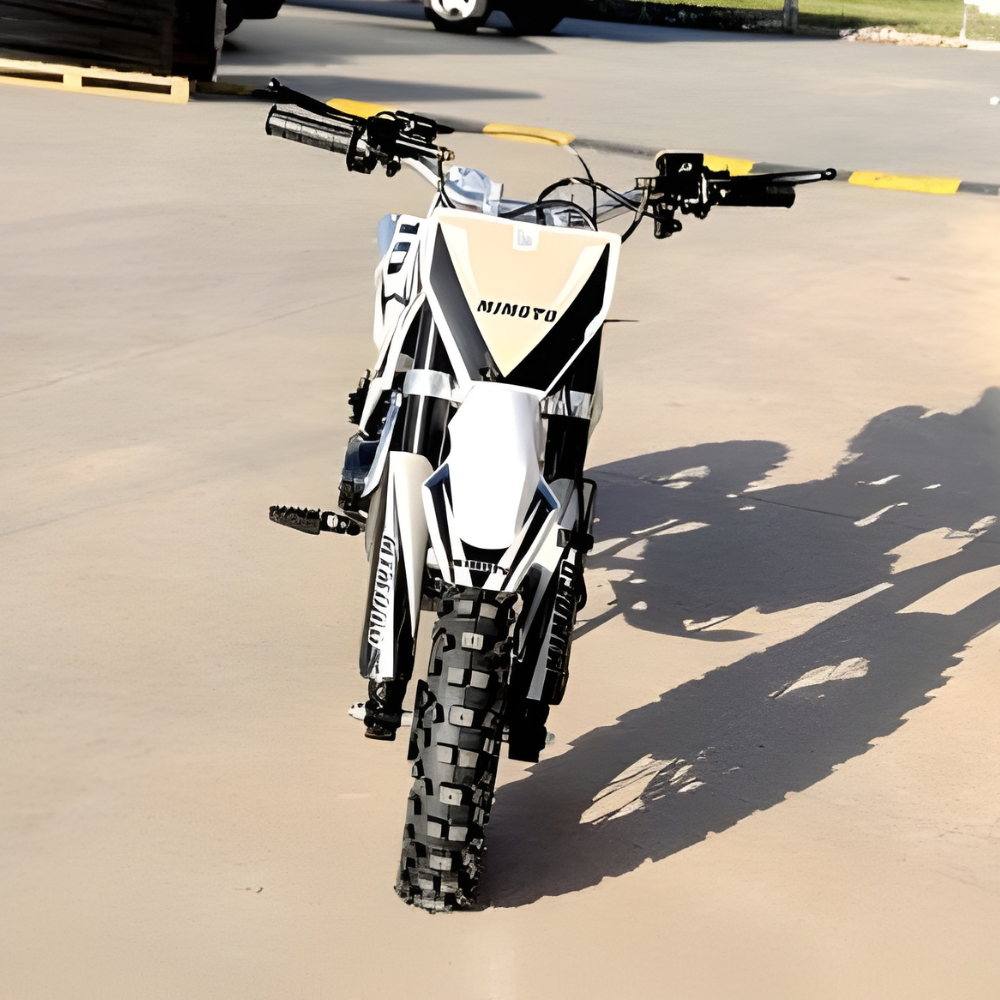 White and black dirt bike with 'Mimoto' branding on a paved surface.