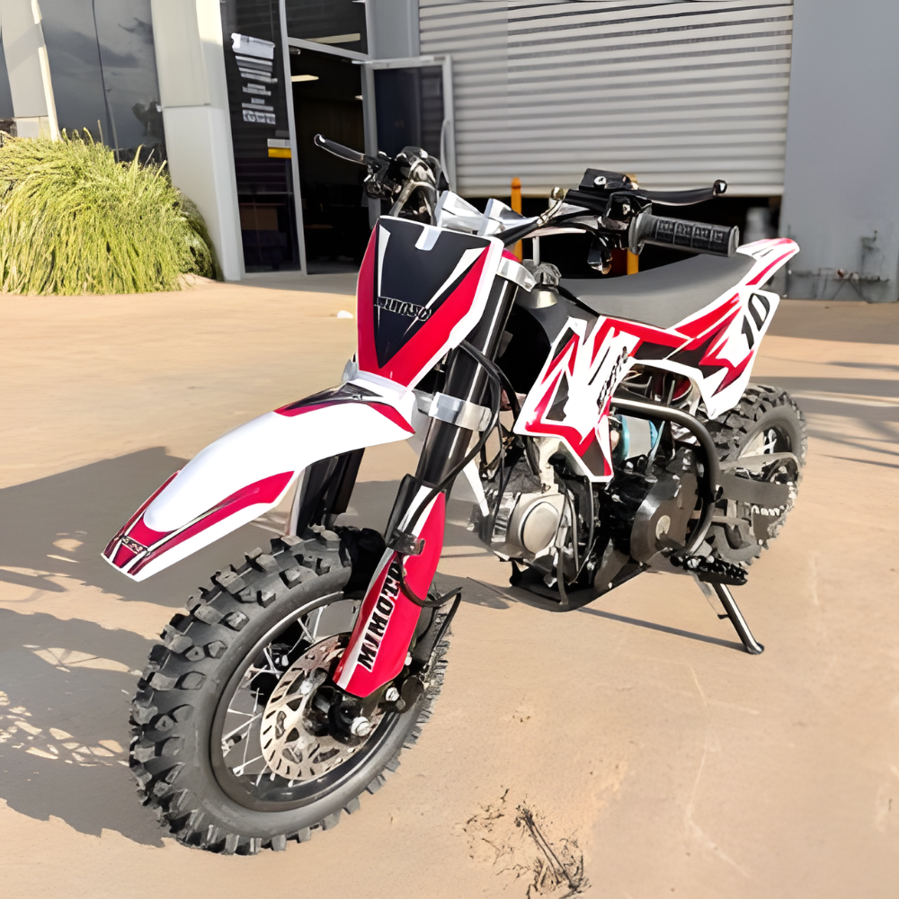 Red and white dirt bike parked on a concrete surface.
