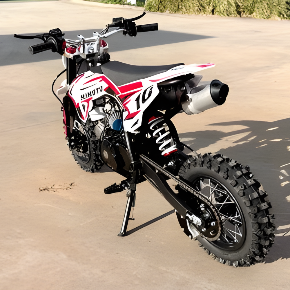 Small dirt bike on a sandy surface with a blurred natural background