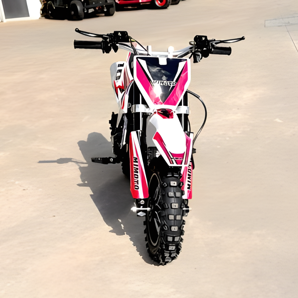 Small dirt bike with a red and white design on a concrete surface