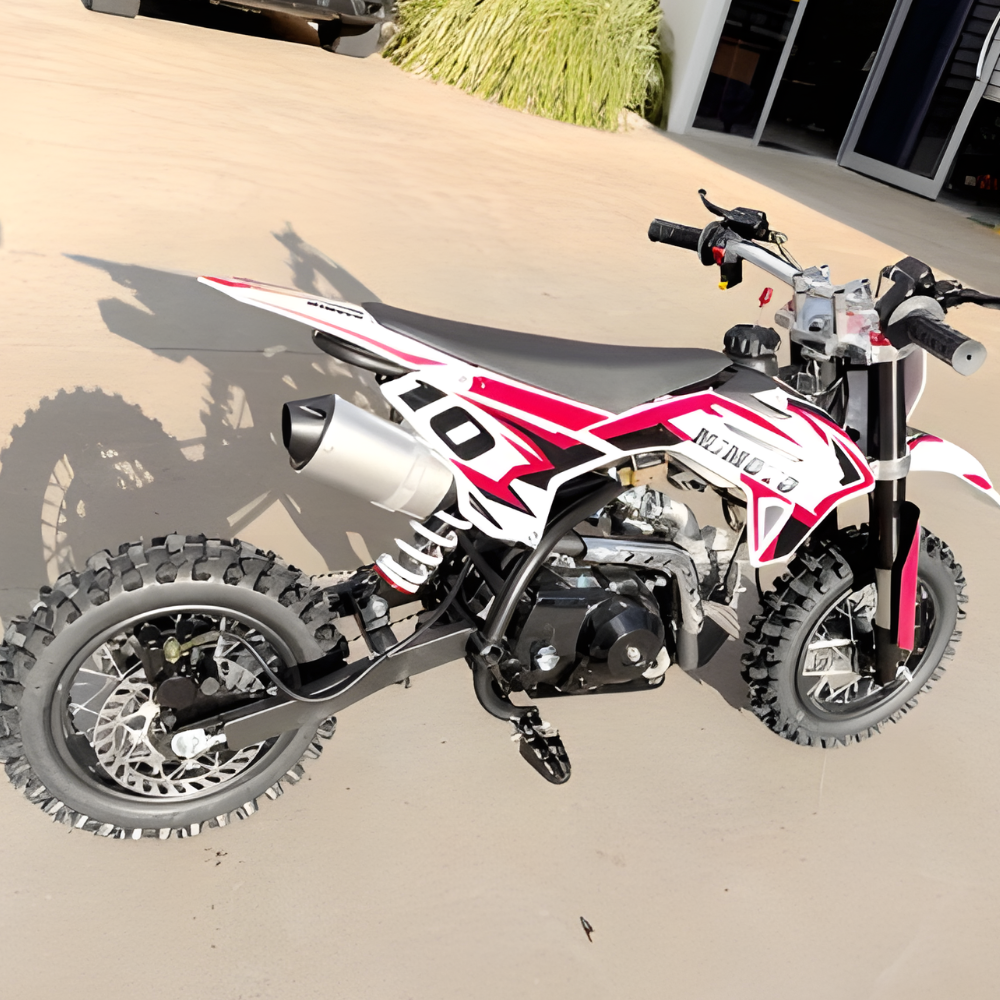 Red and white dirt bike on a concrete surface with a building in the background