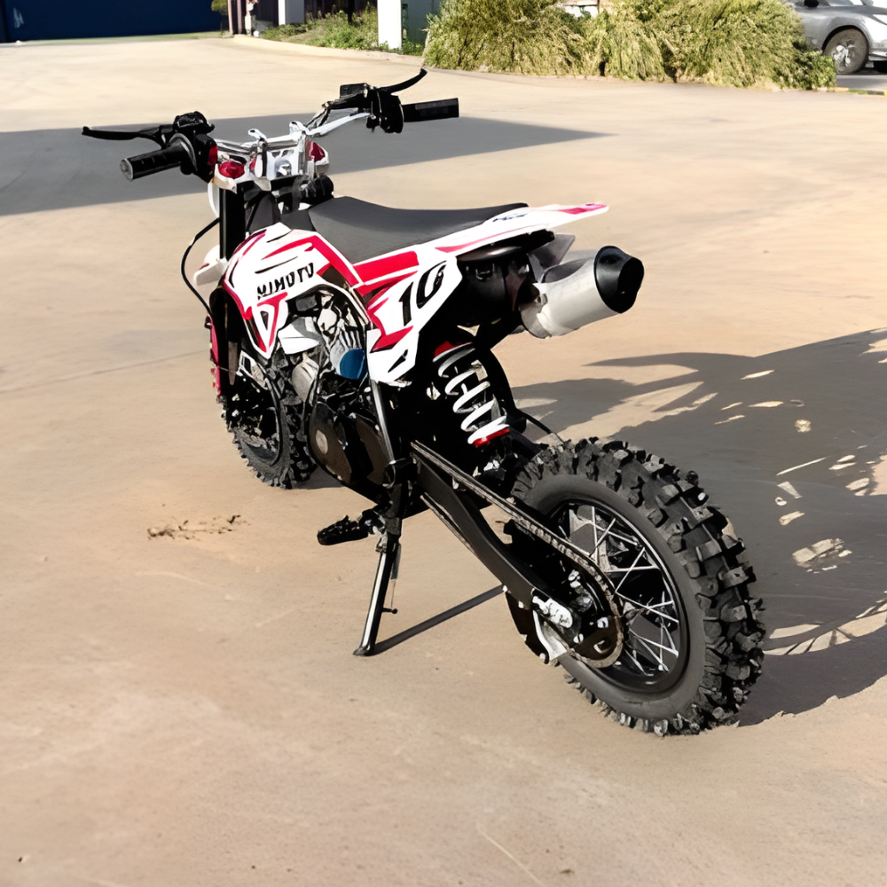 Small dirt bike on a concrete surface with a blurred background